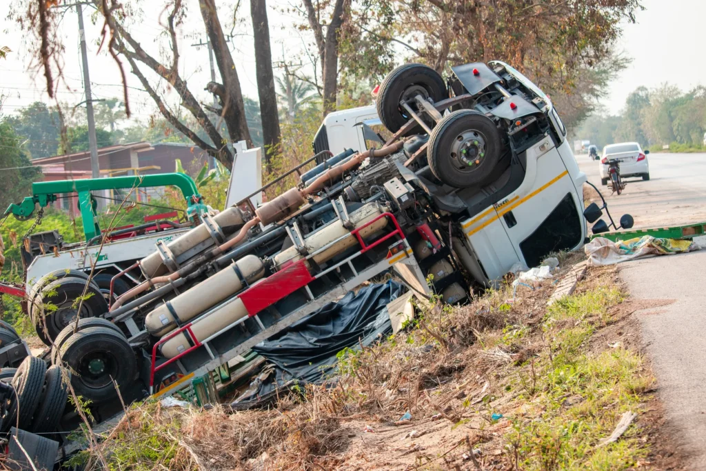 A truck flipped over on the side of the road.