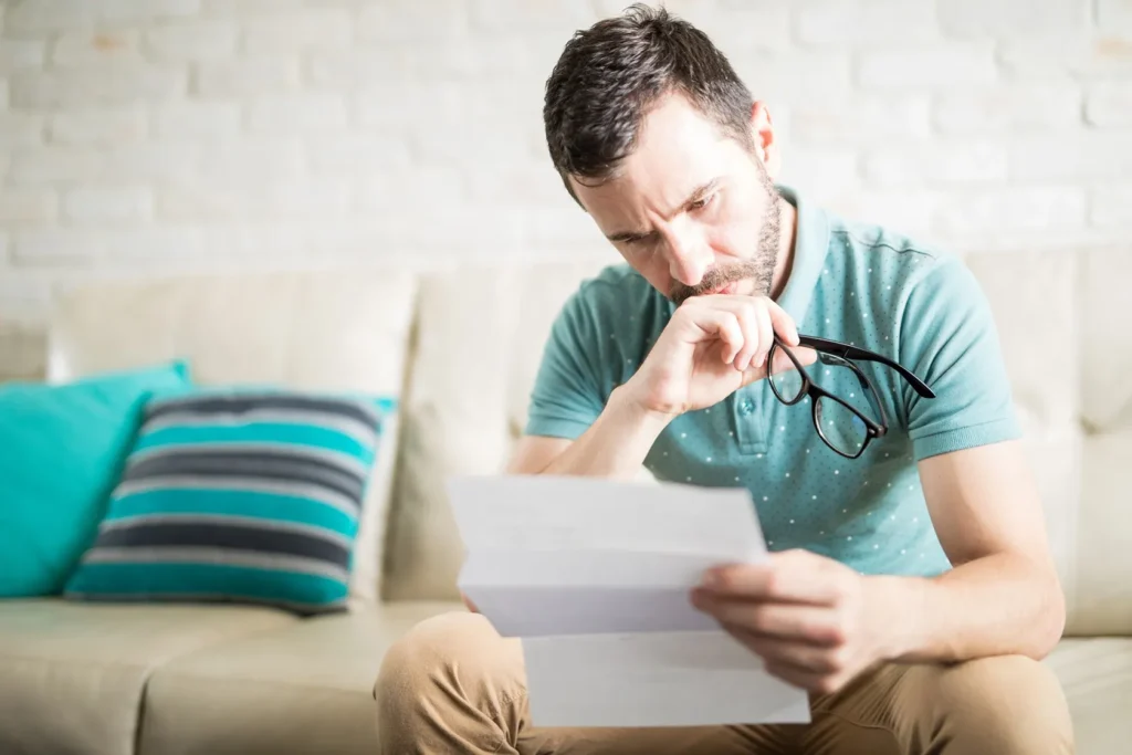 A man reviewing a workers' comp denial letter.