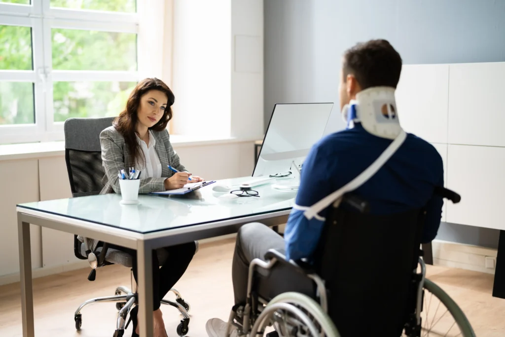 Injured employee in wheelchair speaking with an attorney.